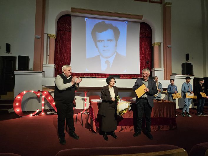 Absolut emoționant: profesoara Rodica Ghiorghiță omagiind alături de Cătălin Gherghe memoria distinsului profesor Vasile Ghiorghiță în sala de festivități a liceului 