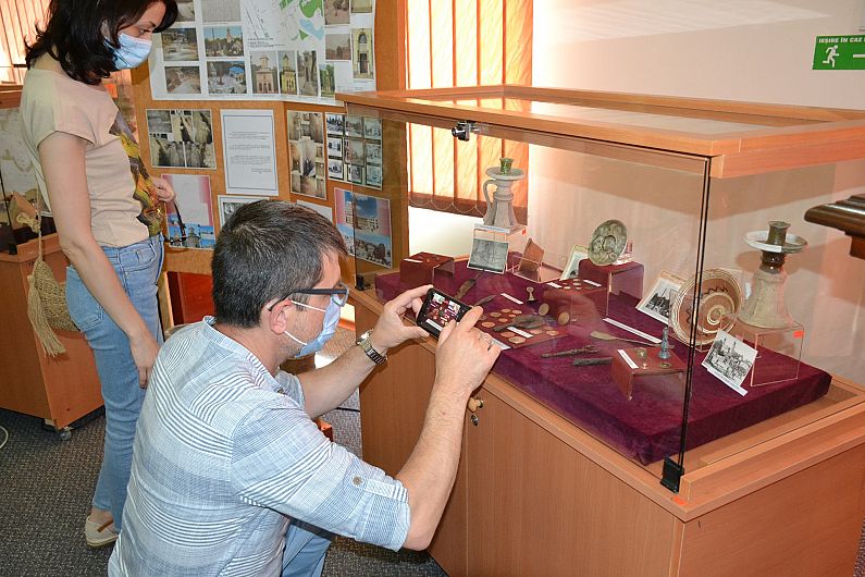 Foto 27 Muzeul Vrancei:Jurnalista Iulia Crețu și Artur Ghinea, admirând și fotografiind monedele descoperite în Piața Unirii.